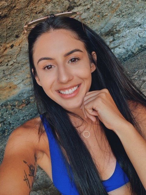 A woman in a blue bikini top is smiling for the camera