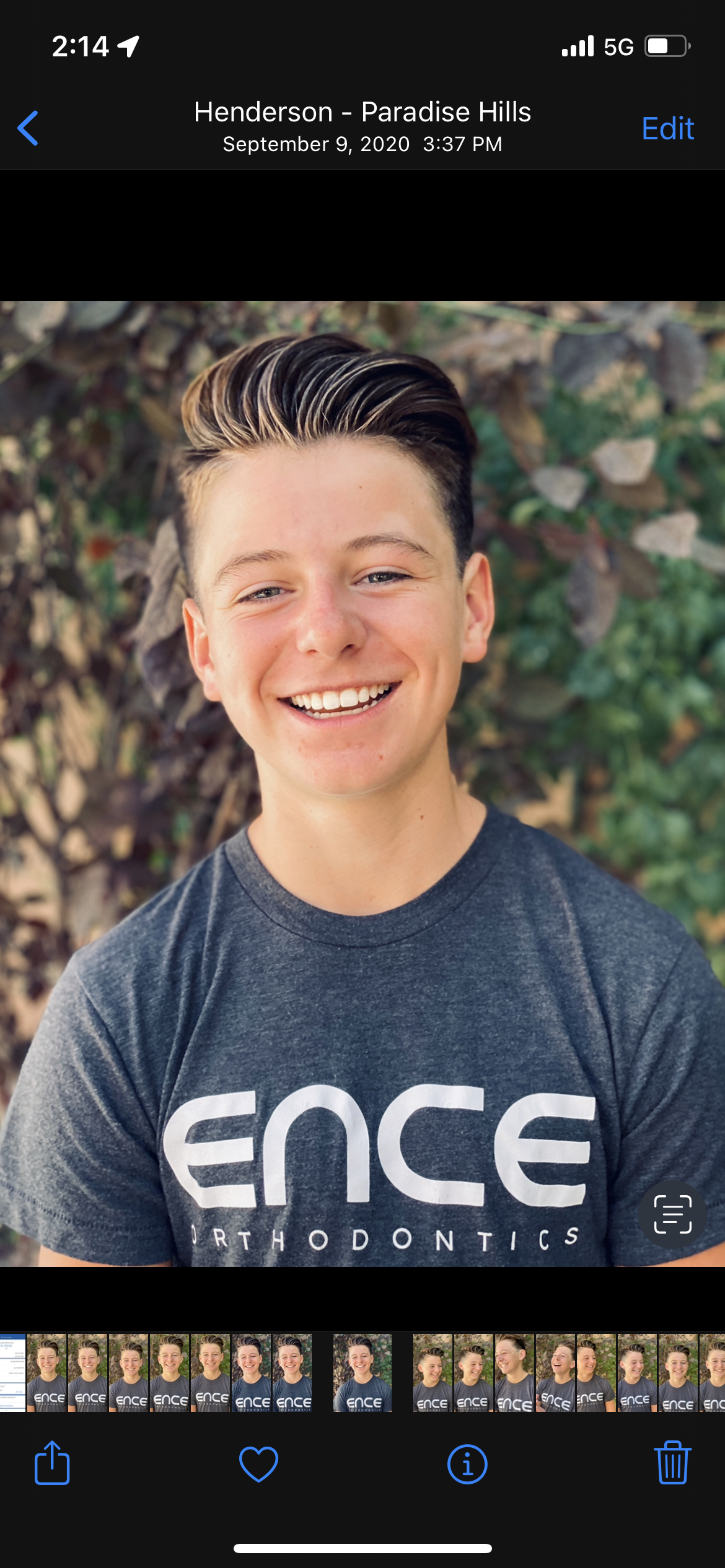 A young man wearing a fence t-shirt is smiling for the camera.
