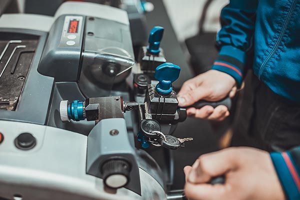 A person is cutting a key with a machine.