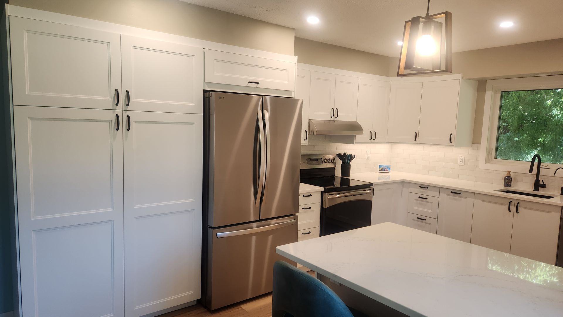 A kitchen with white cabinets and stainless steel appliances.