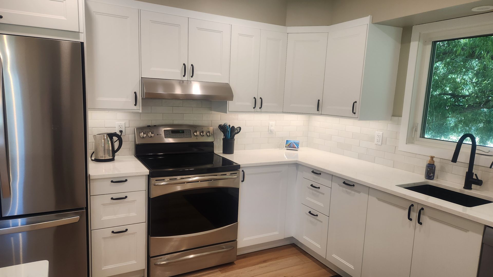 A kitchen with white cabinets and stainless steel appliances