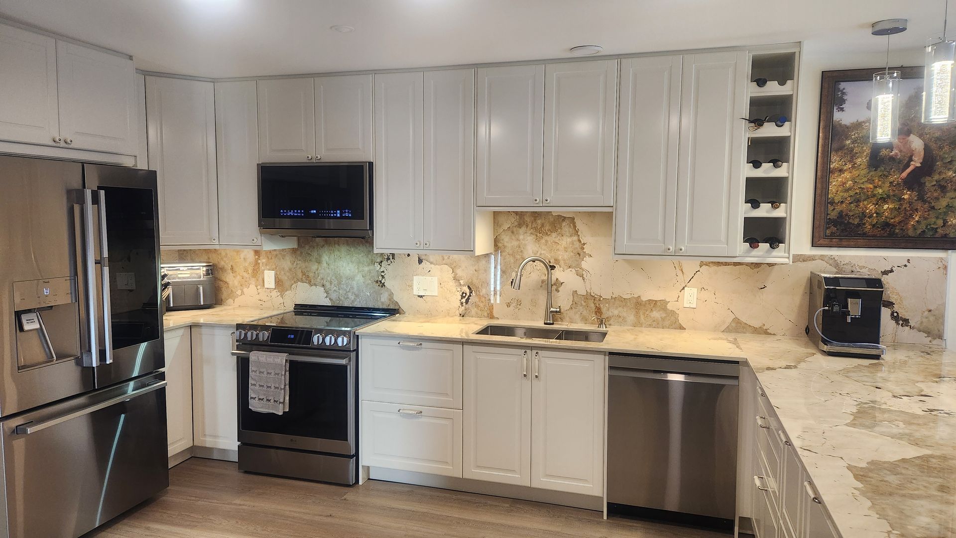 A kitchen with white cabinets and stainless steel appliances