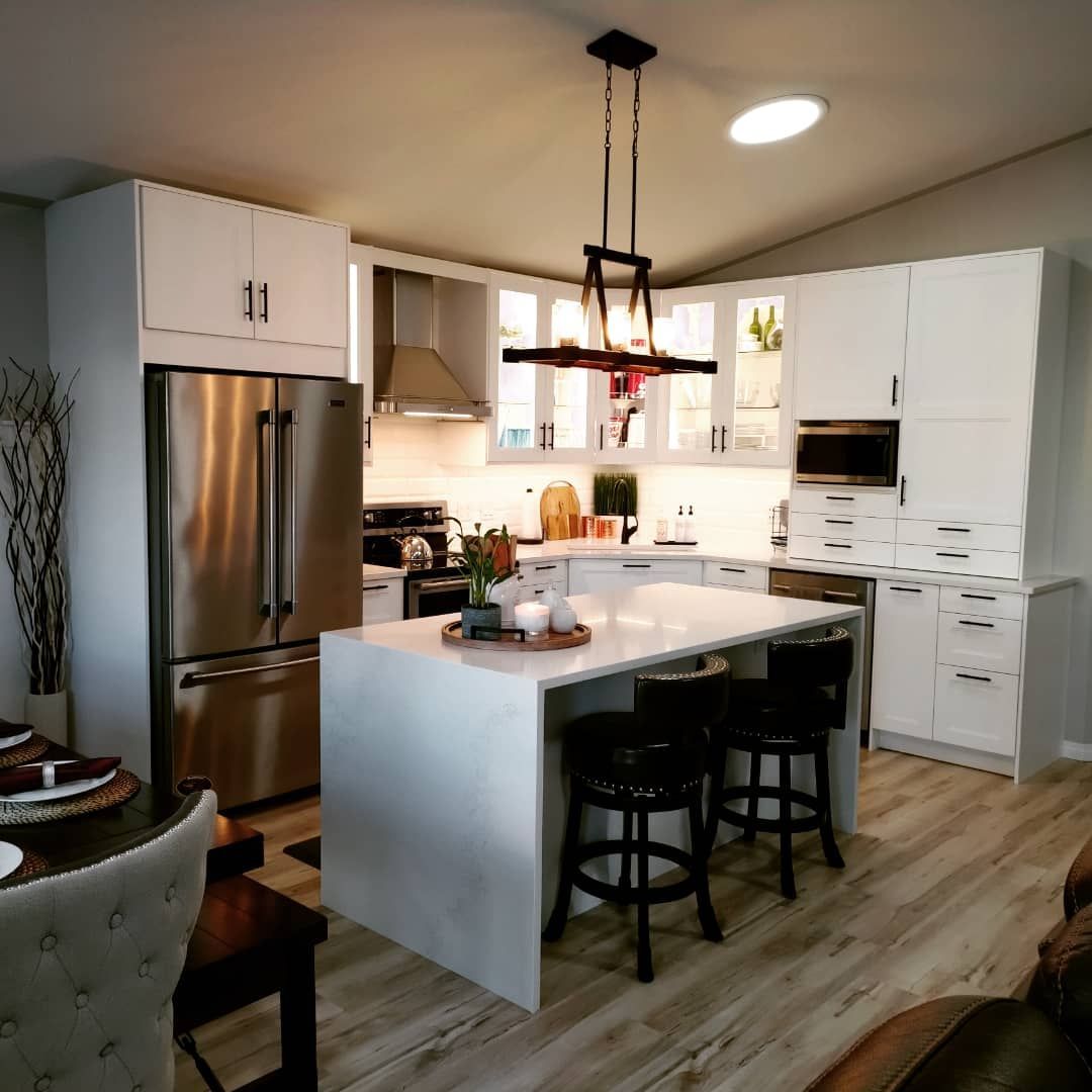 A kitchen with white cabinets and stainless steel appliances