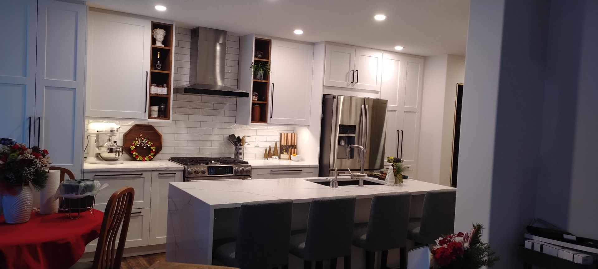 A kitchen with white cabinets , stainless steel appliances and a large island.