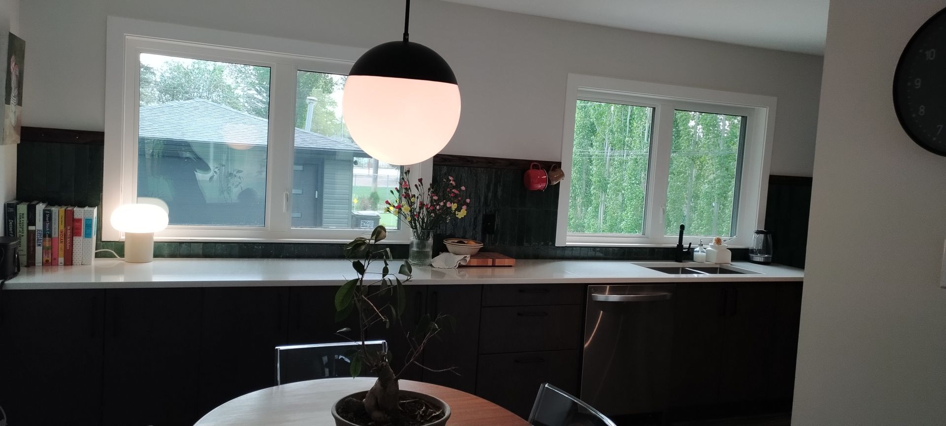 A kitchen with a table and chairs and a potted plant on the counter.
