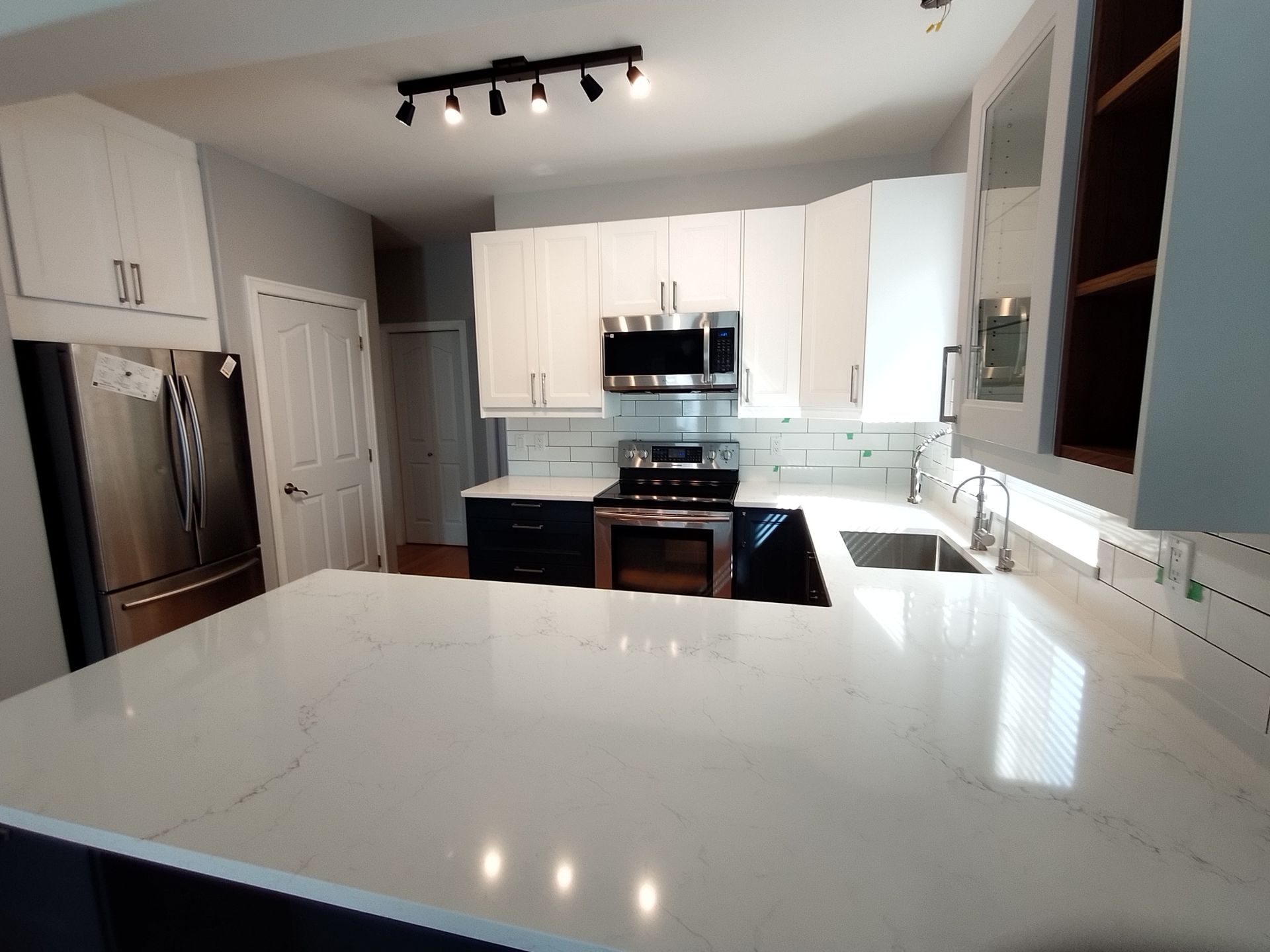 A kitchen with white cabinets and stainless steel appliances