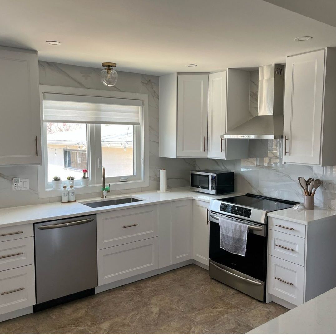 A kitchen with white cabinets and stainless steel appliances