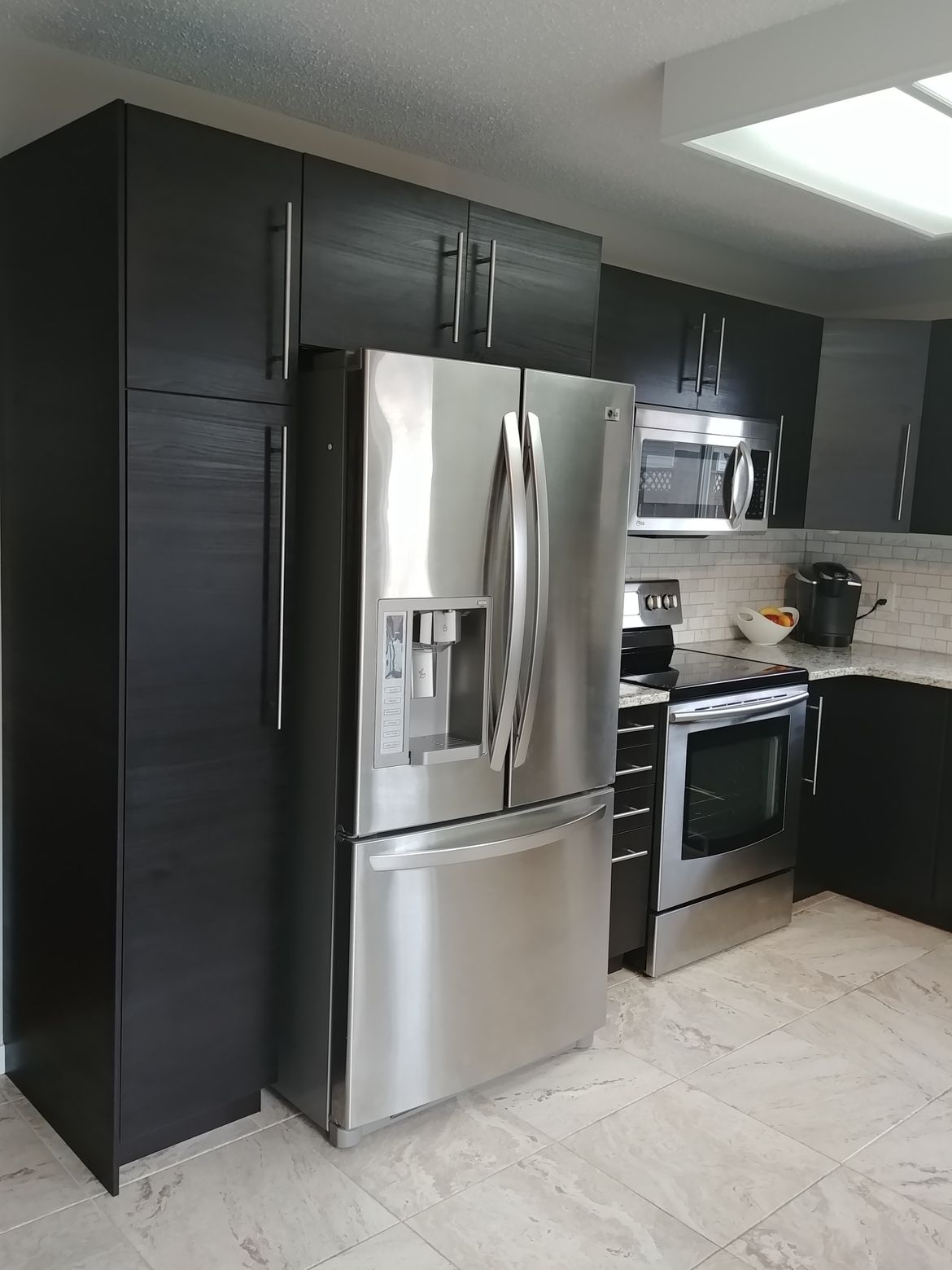 A kitchen with stainless steel appliances and black cabinets