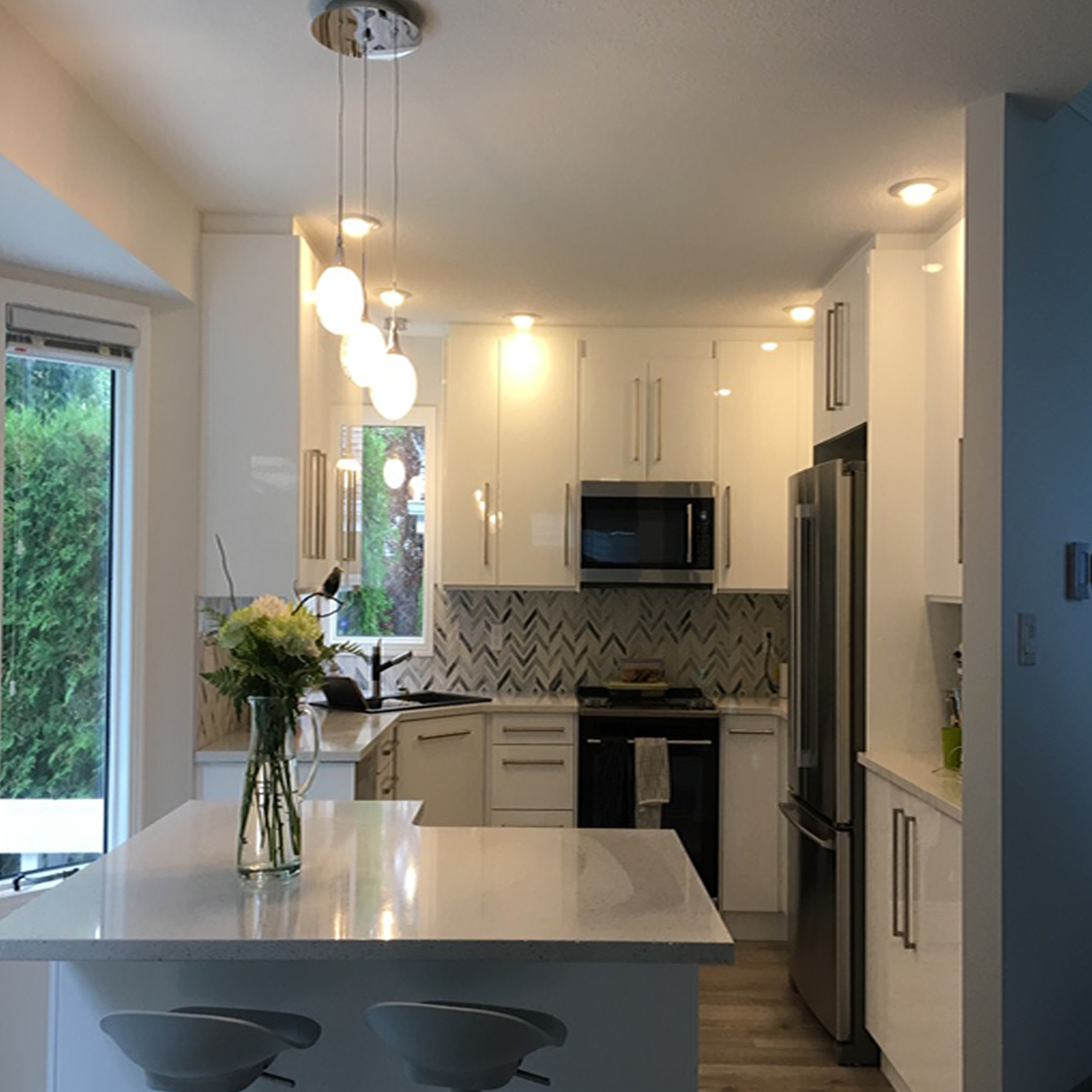 A kitchen with white cabinets and stainless steel appliances