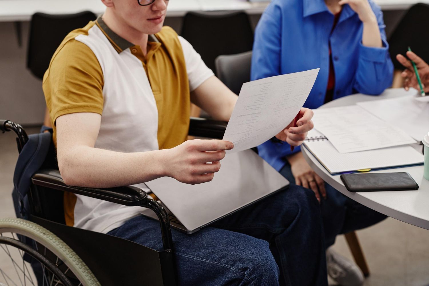 People seated at a table reviewing papers during a meeting