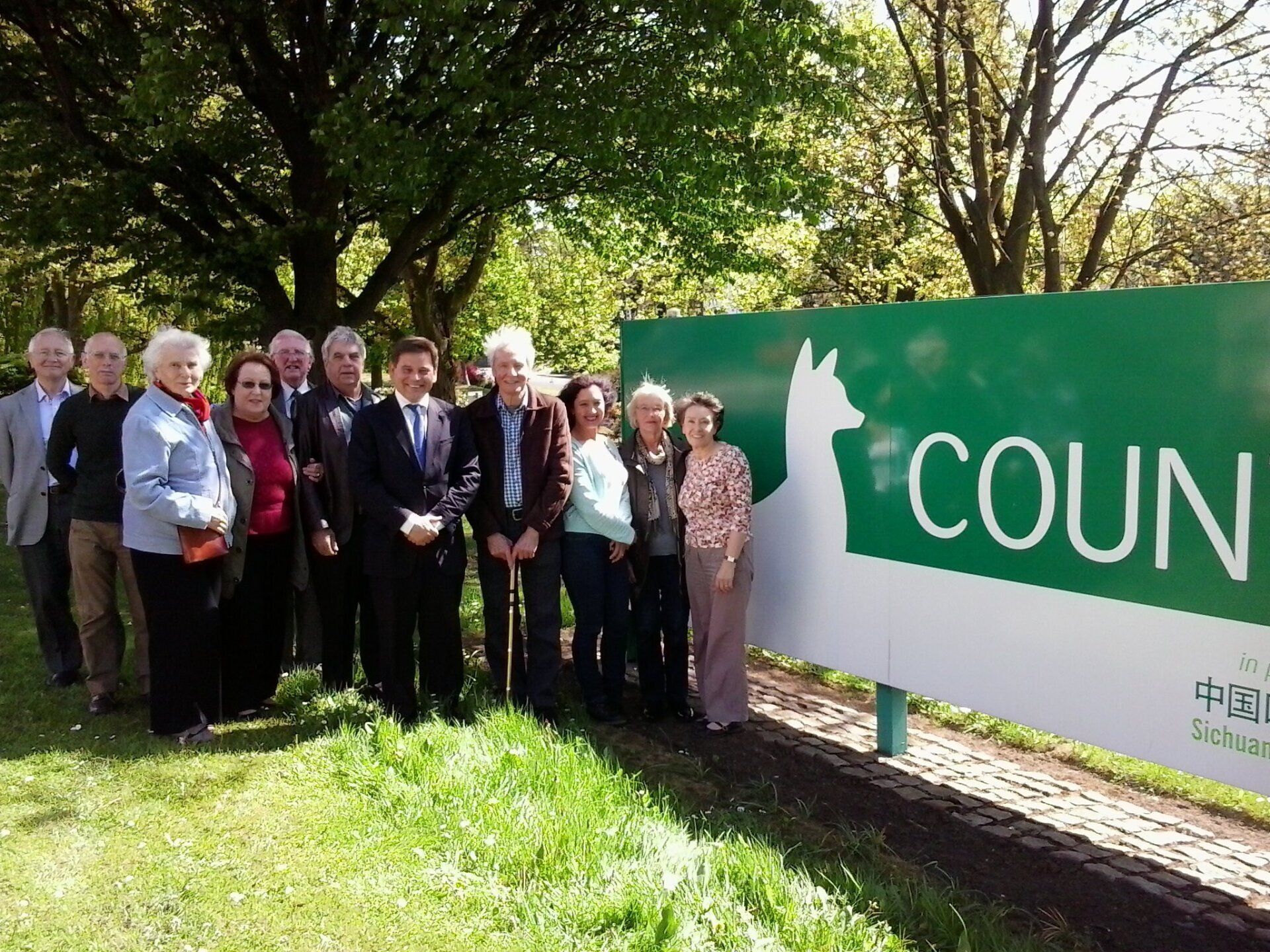 A group of people standing in front of a sign that says coun