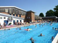 A group of people are swimming in a large swimming pool.