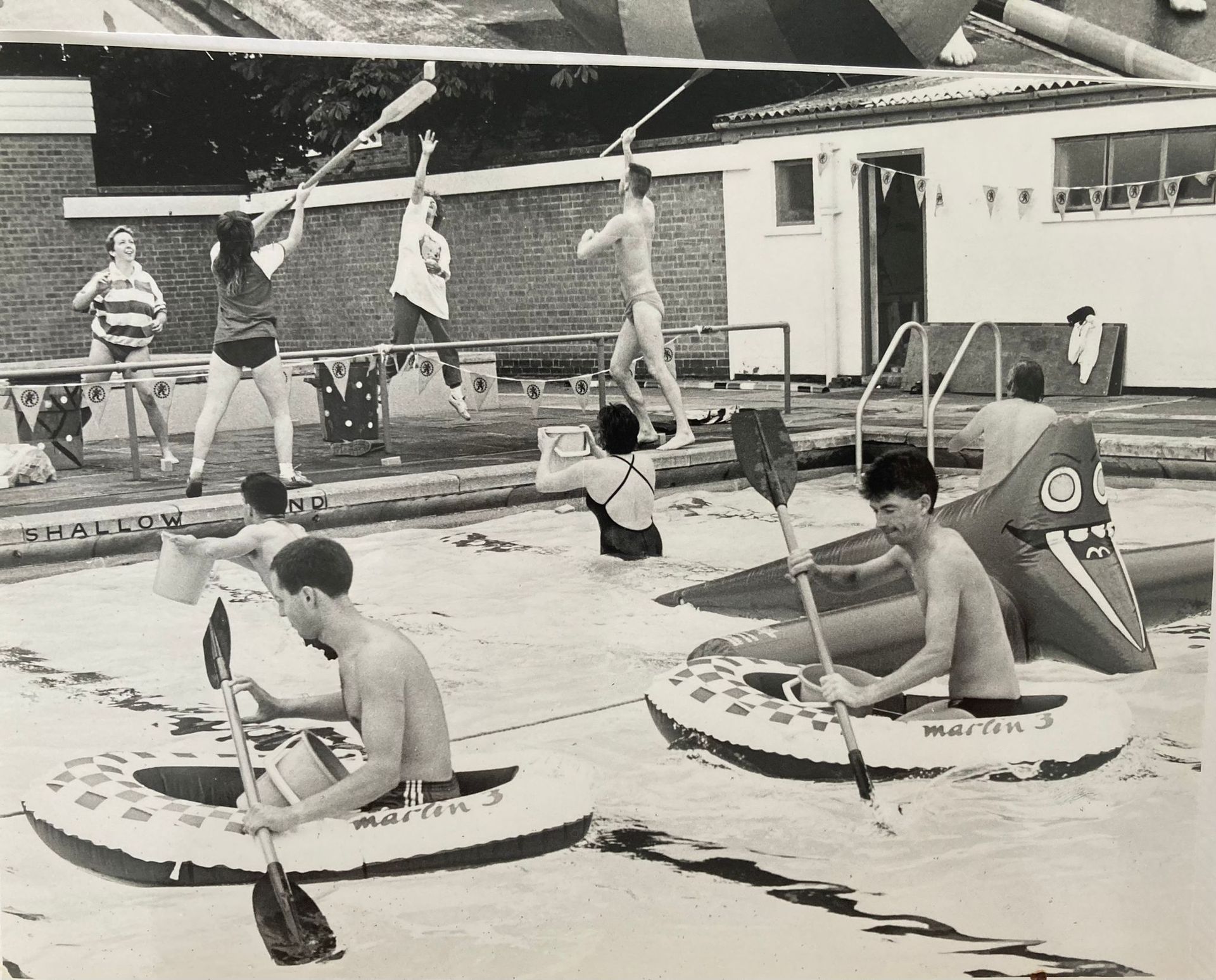A black and white photo of a group of people in rafts
