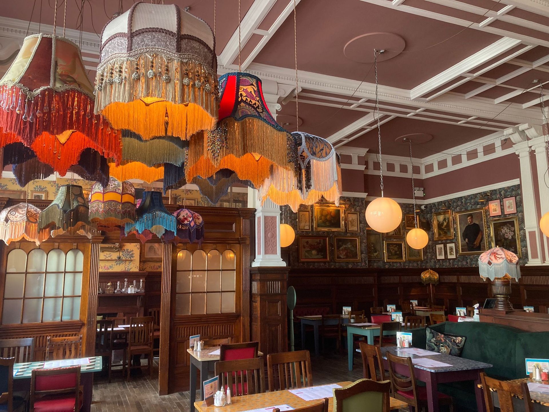 A restaurant with tables and chairs and umbrellas hanging from the ceiling.