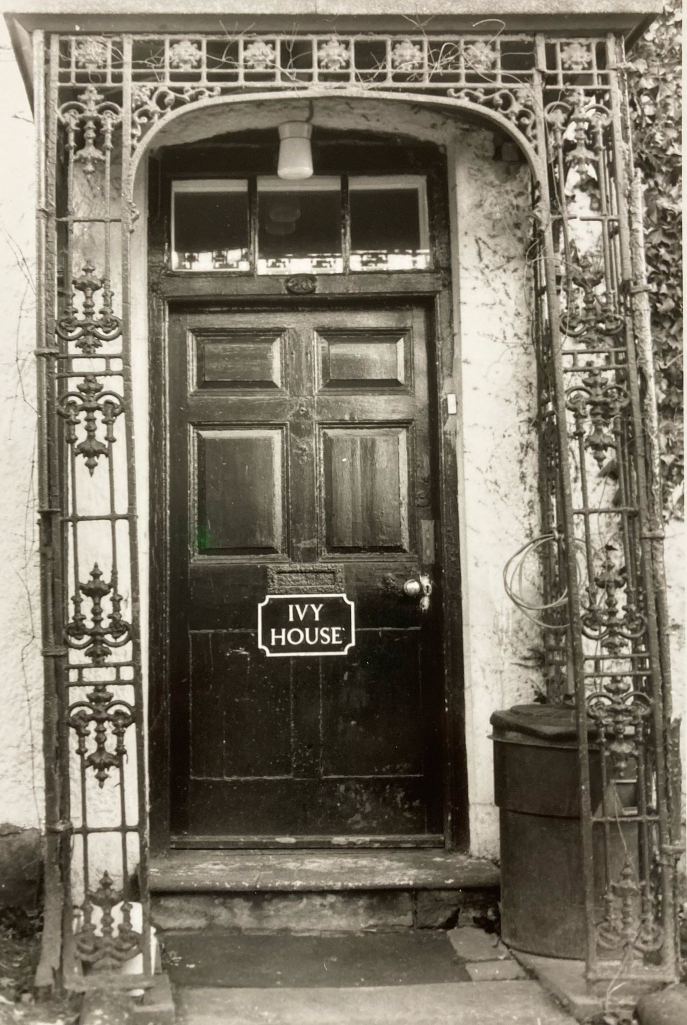 A black and white photo of a door that says my house