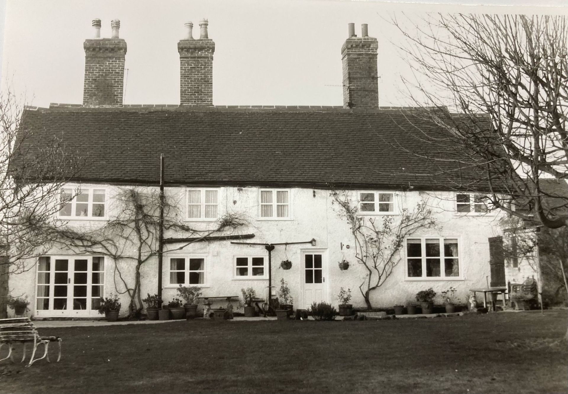 A black and white photo of a house with chimneys