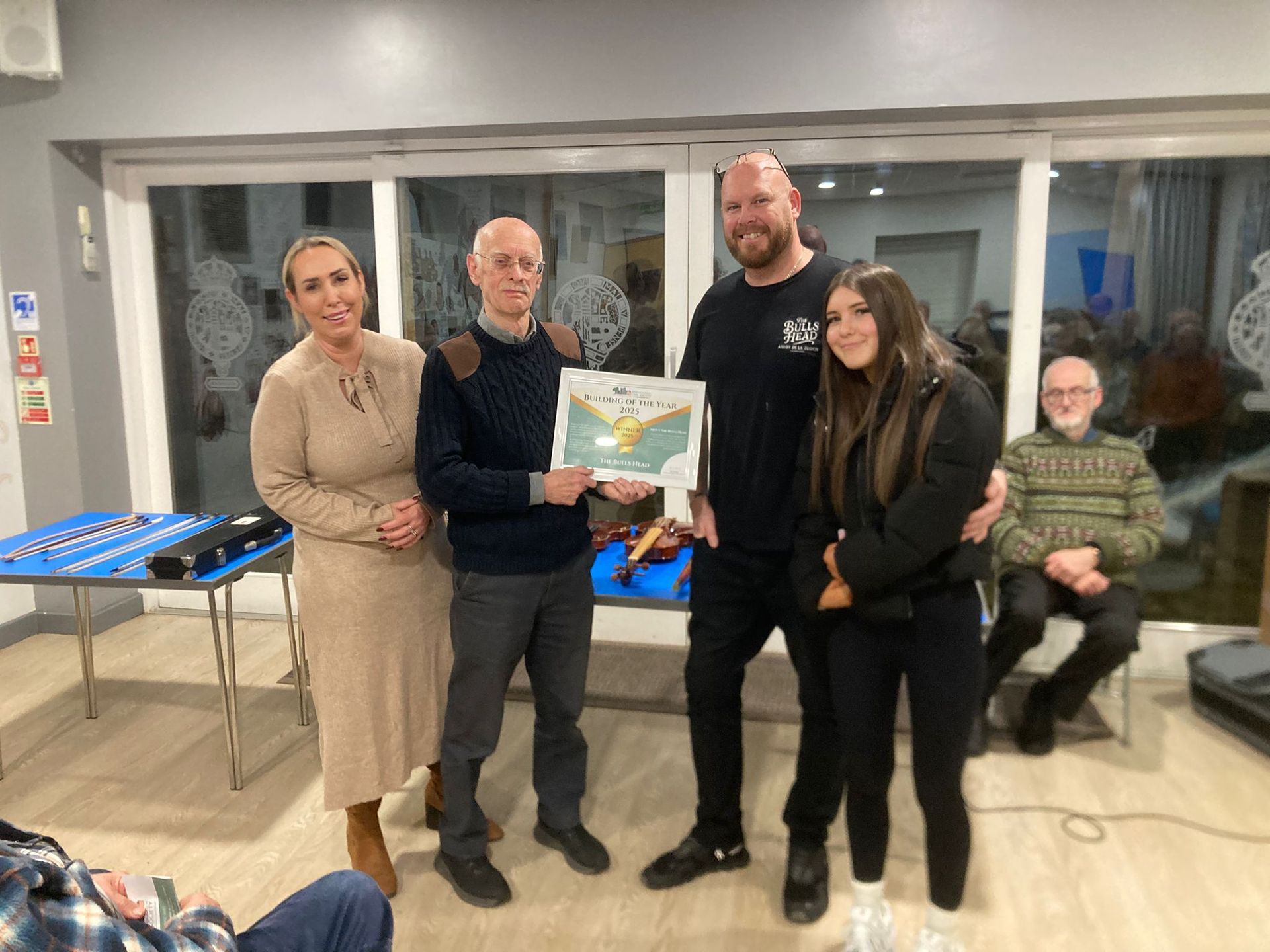 A group of people are standing next to each other in a room holding plaques.