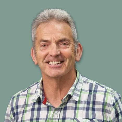 Goff Lewis in a plaid shirt is smiling for the camera.