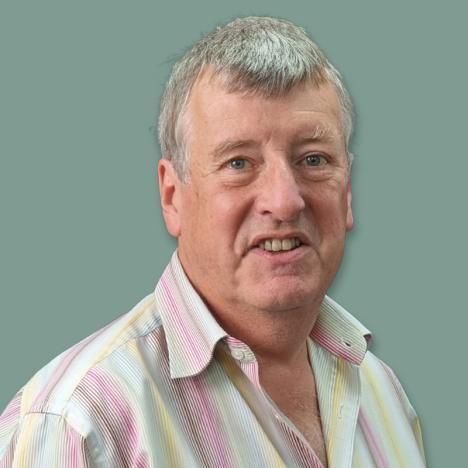 Richard Jameson in a striped shirt is smiling for the camera.