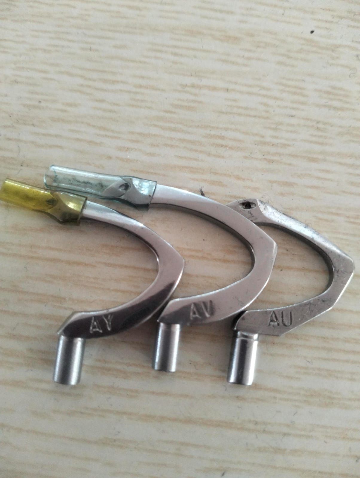 Tres piezas metálicas de máquina de coser con las marcas