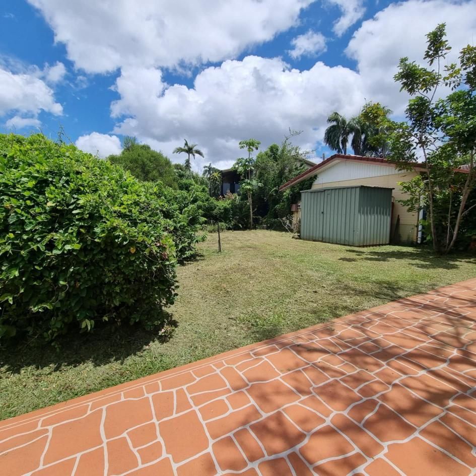 A Brick Driveway Leading To A House With A Green Garage Door — City 2 Bush Mowing Services Darwin In Howard Springs, NT
