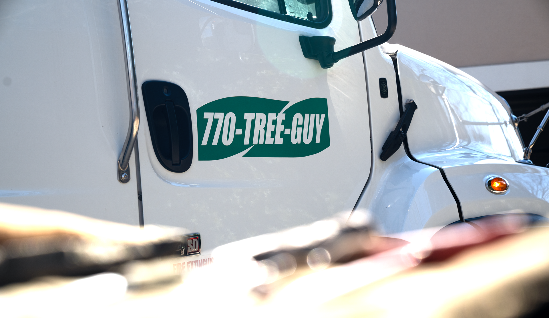 a white truck that says 770-tree-guy on the side