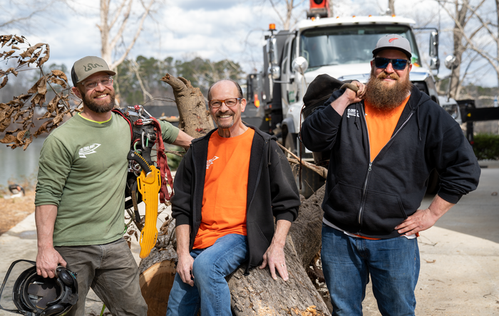 three men are posing for a picture in front of a truck that says lsu