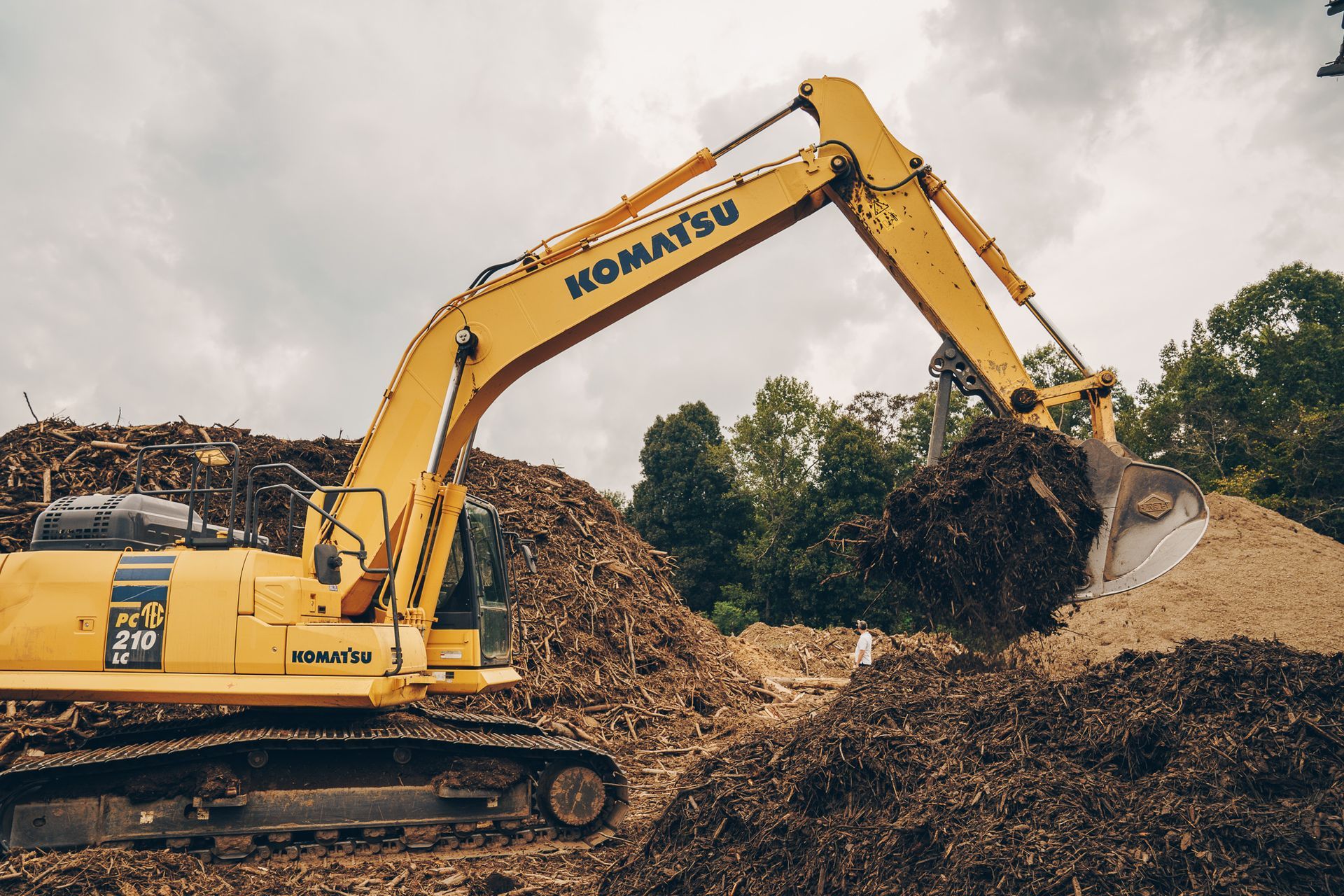 a komatsu excavator is digging in a pile of dirt