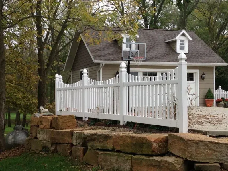 A house with a white picket fence and a basketball hoop in front of it