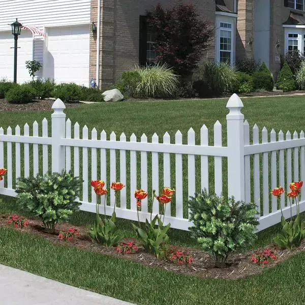 A white picket fence with flowers in front of a house
