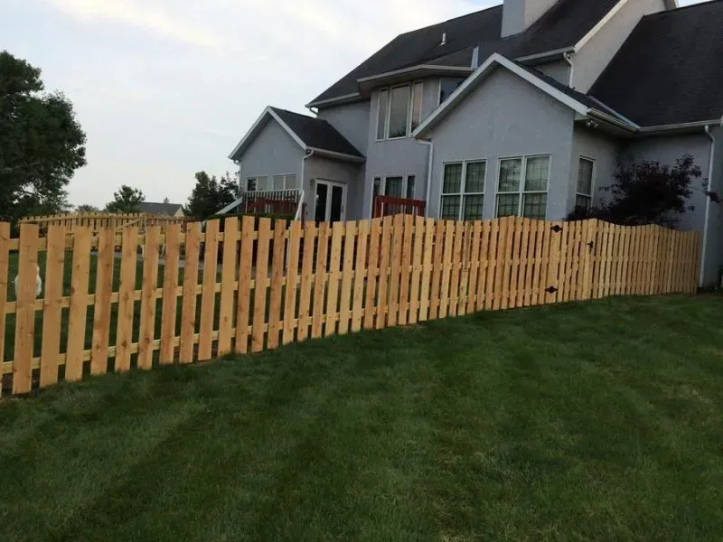 A large house with a wooden fence in front of it