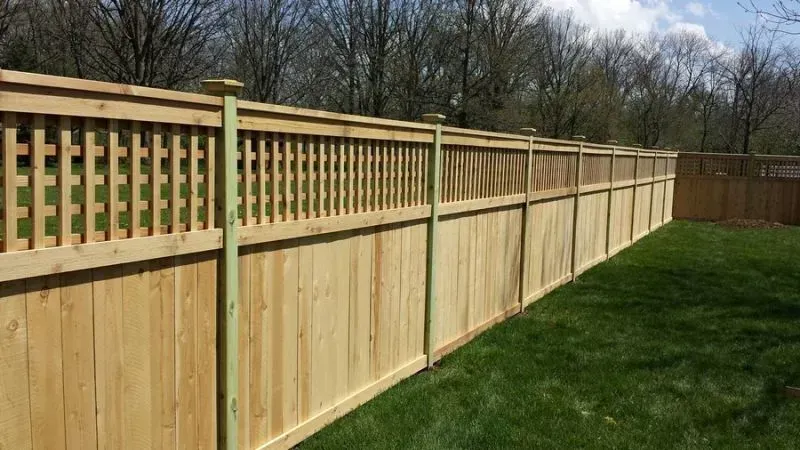 A white fence with a red barn in the background