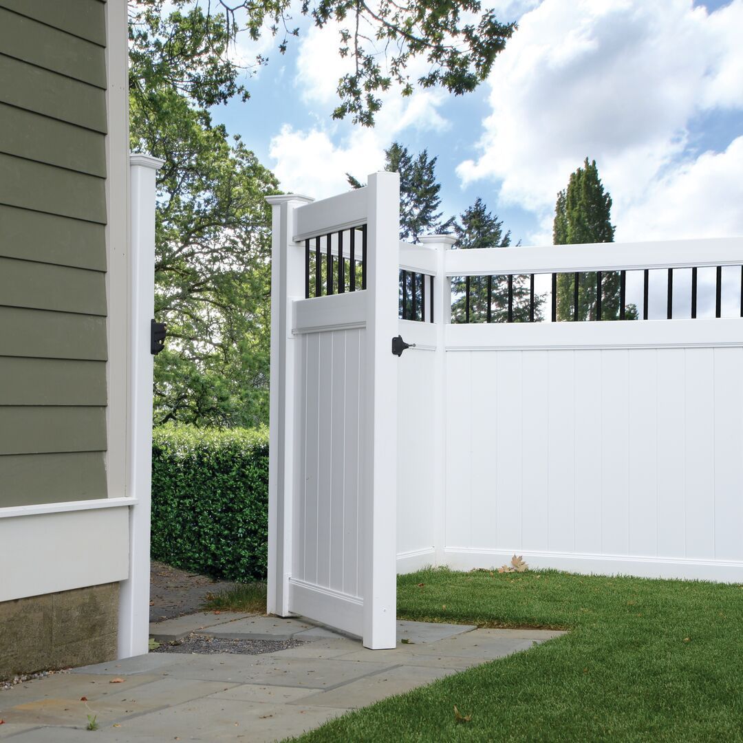 A white fence with a gate that is open