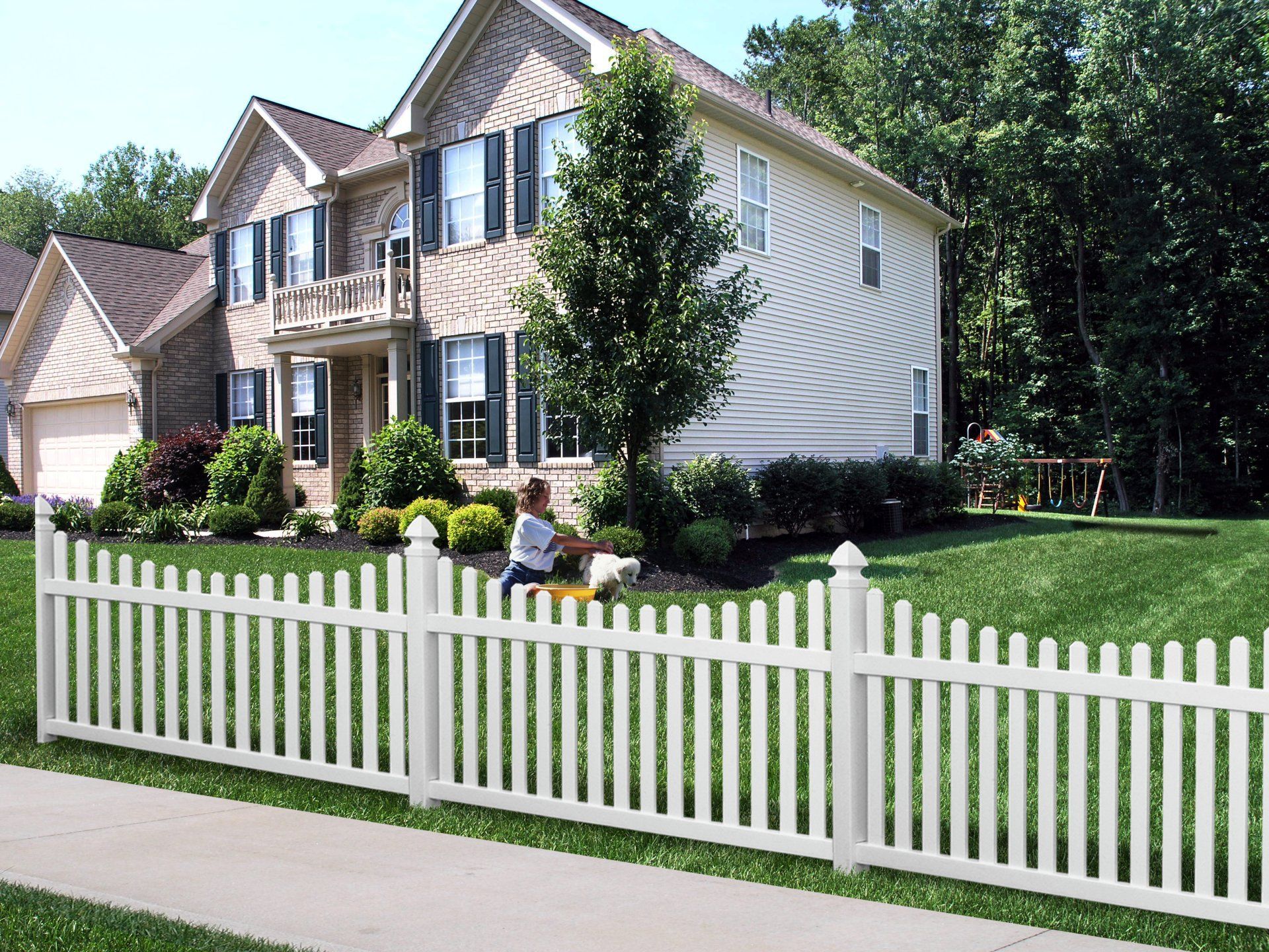 A white picket fence is in front of a house