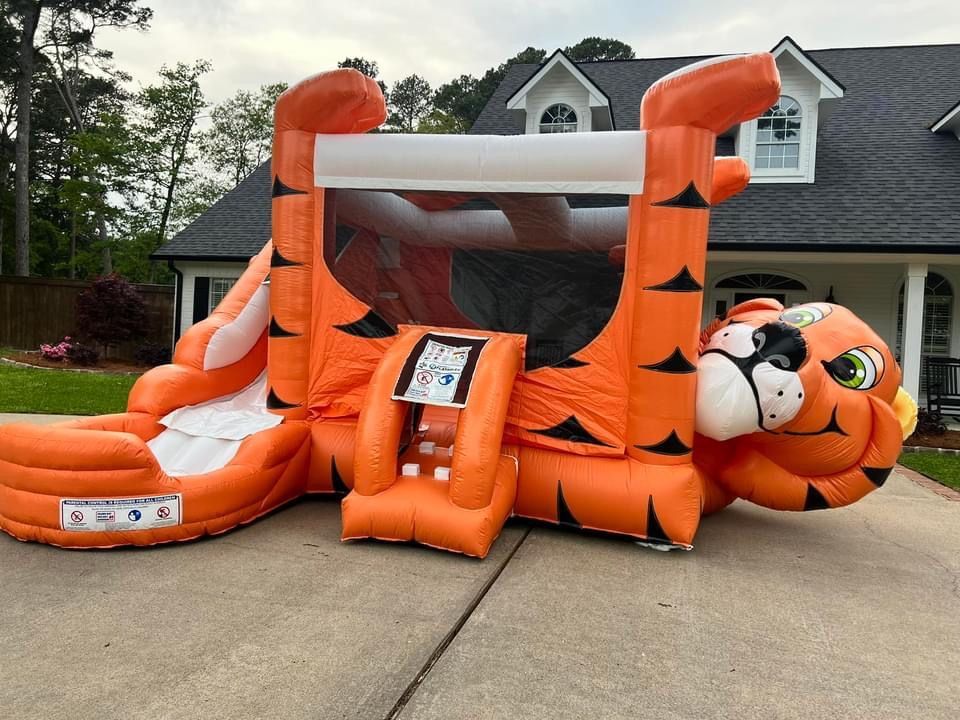 An inflatable tiger bouncy house is sitting in front of a house.