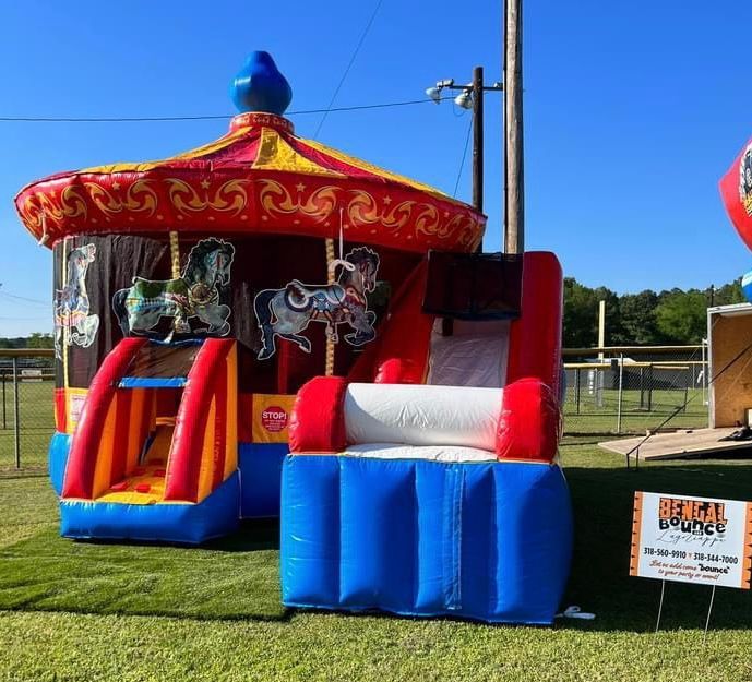 An inflatable merry go round is sitting in a grassy field