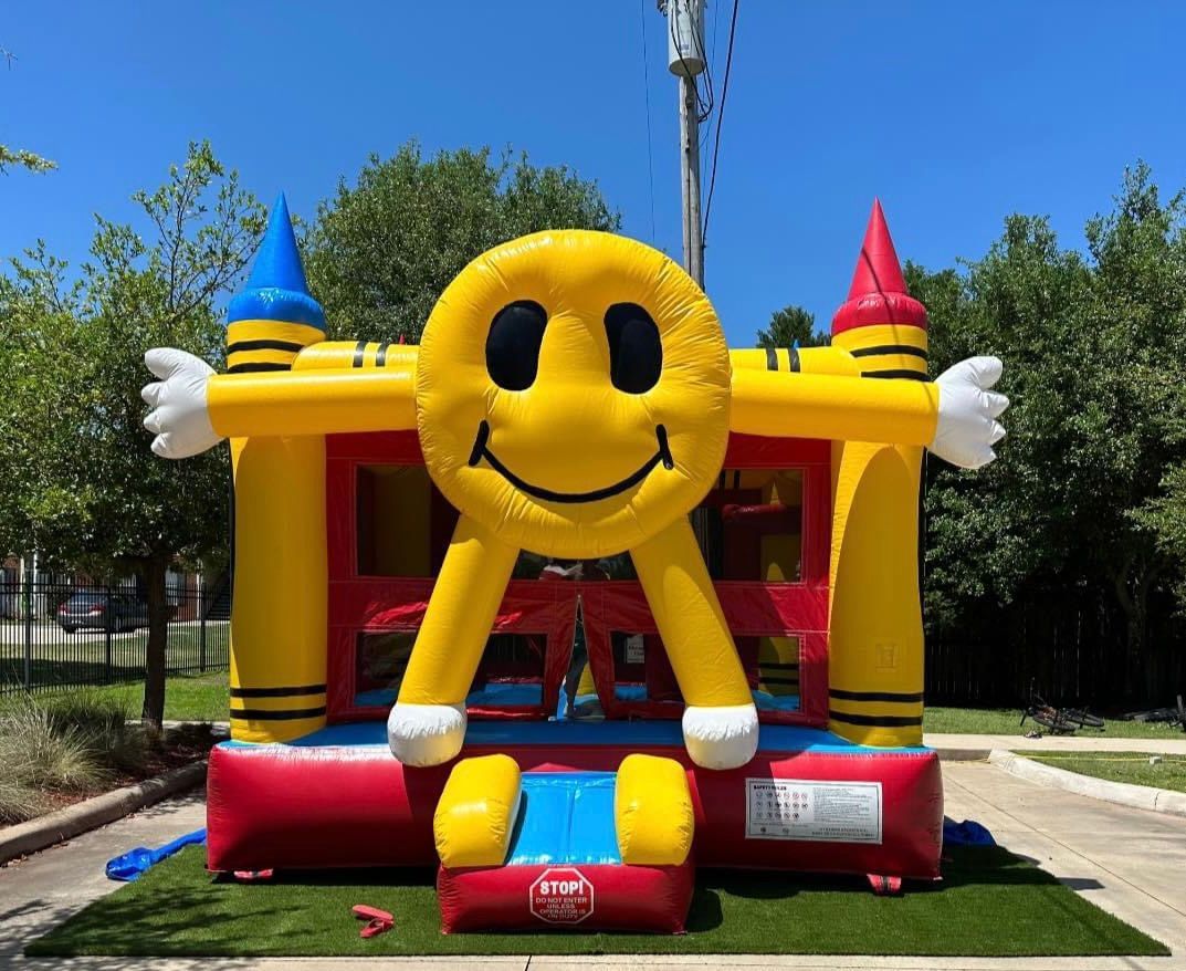 A yellow bouncy house with a smiley face on it.