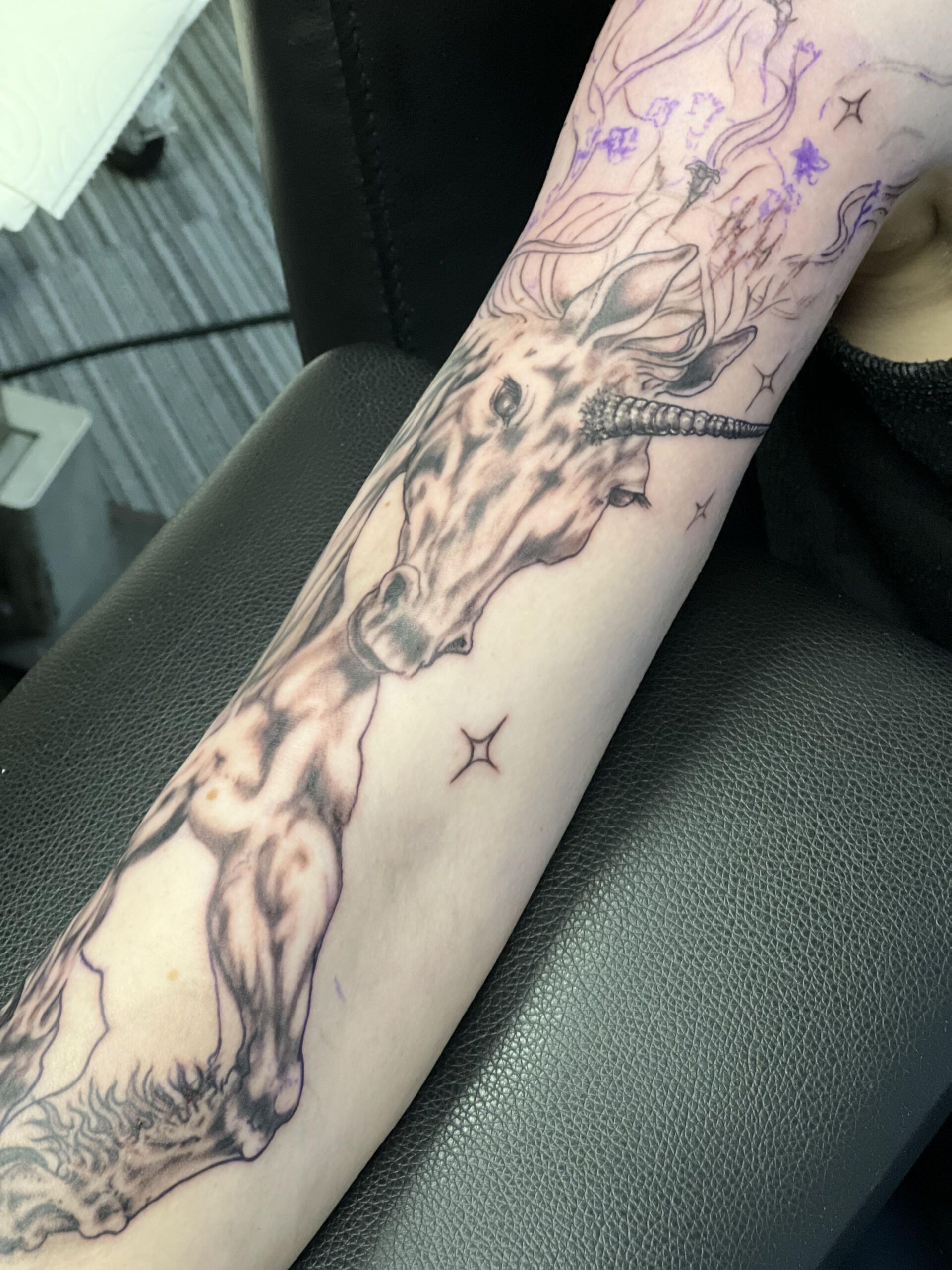 A person has a tattoo of a unicorn on their arm