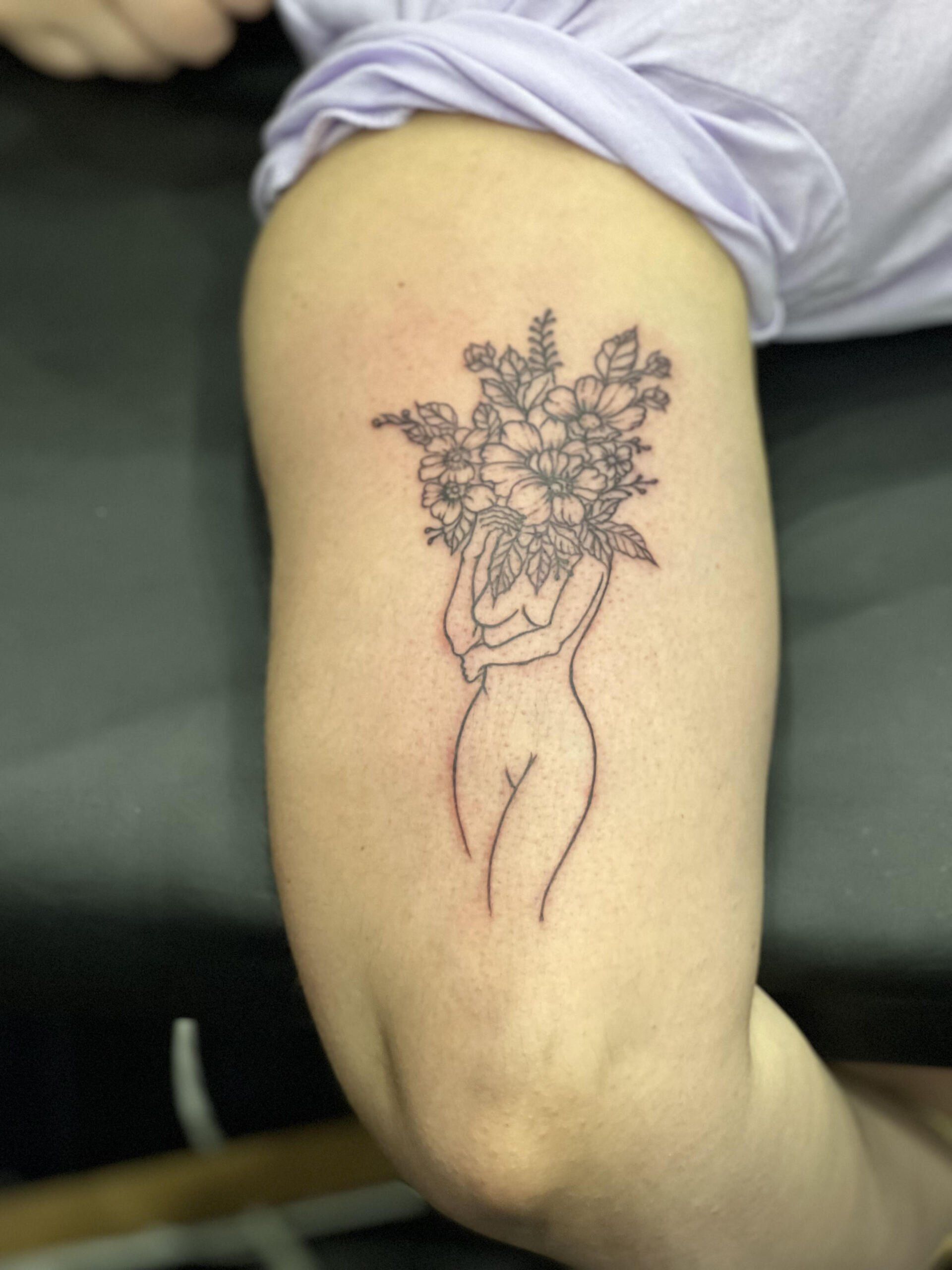 A tattoo of a woman holding a bouquet of flowers