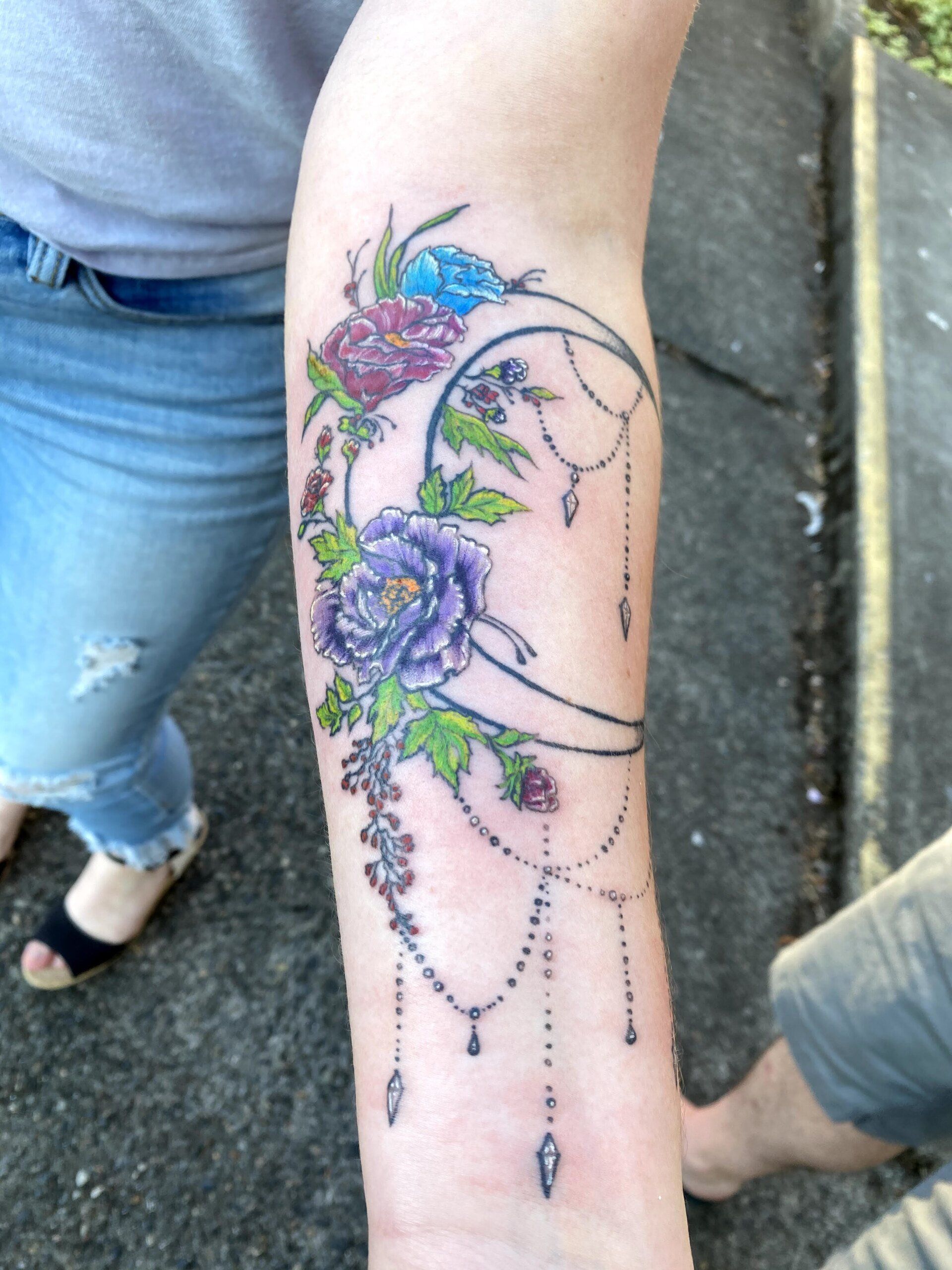 A woman has a tattoo of flowers on her arm