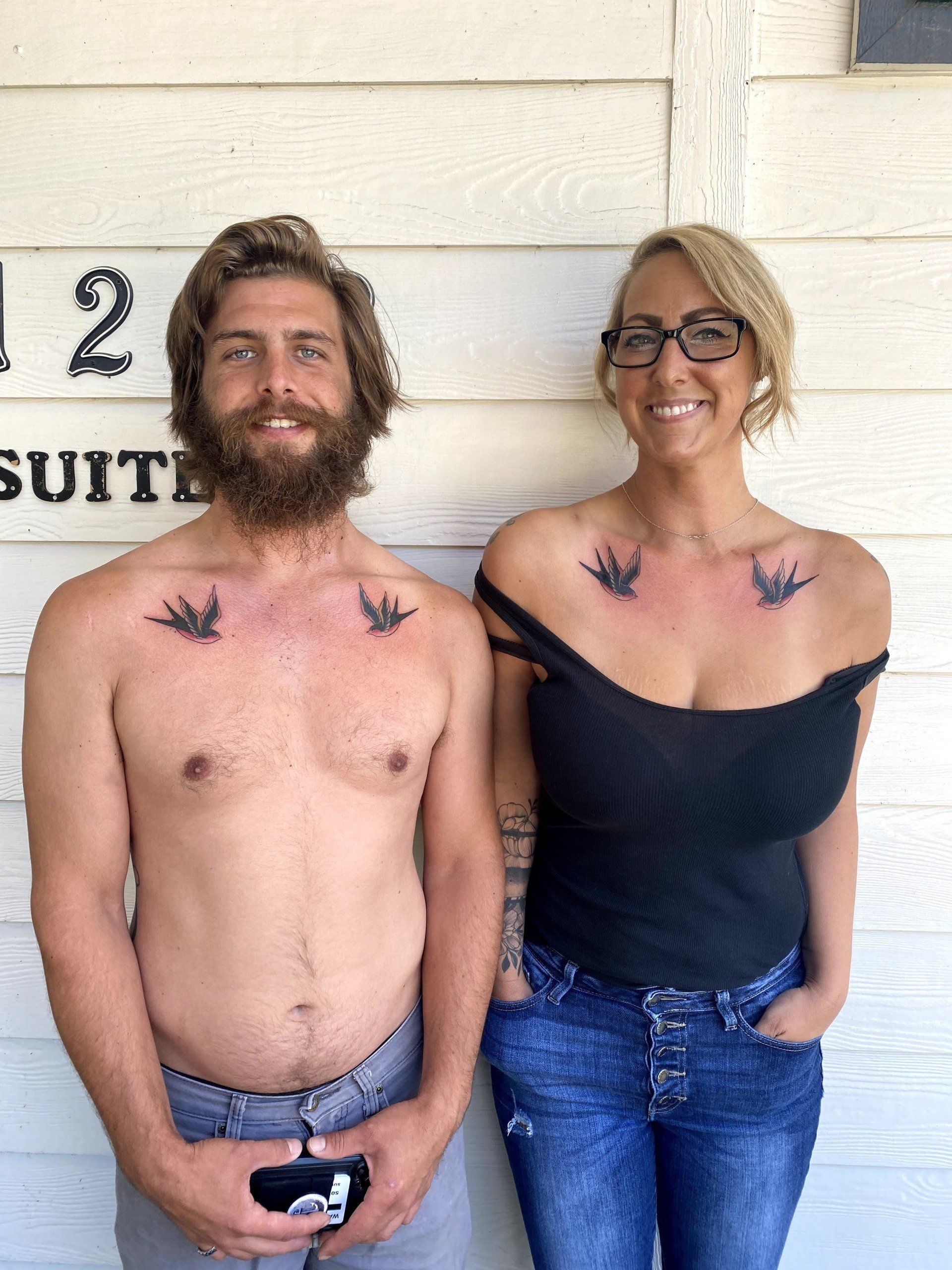 A man and a woman are standing next to each other in front of a building with the number 12 on it