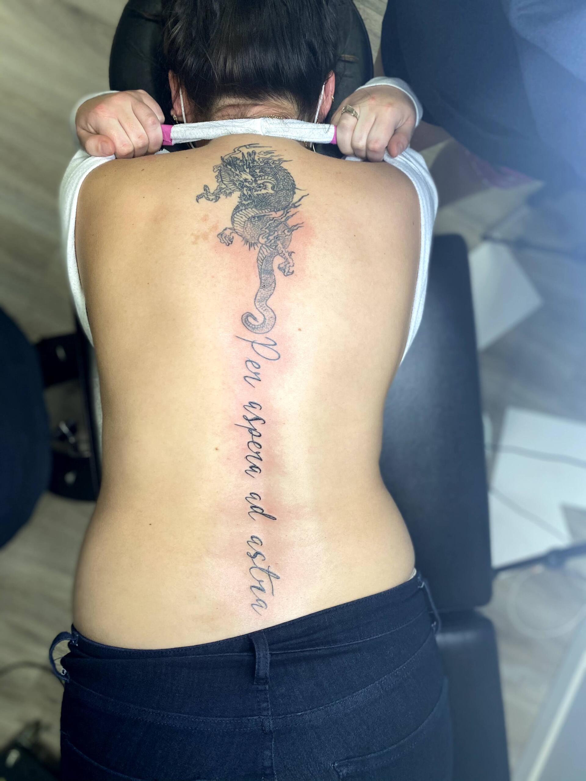 A woman has a tattoo on her back that says 