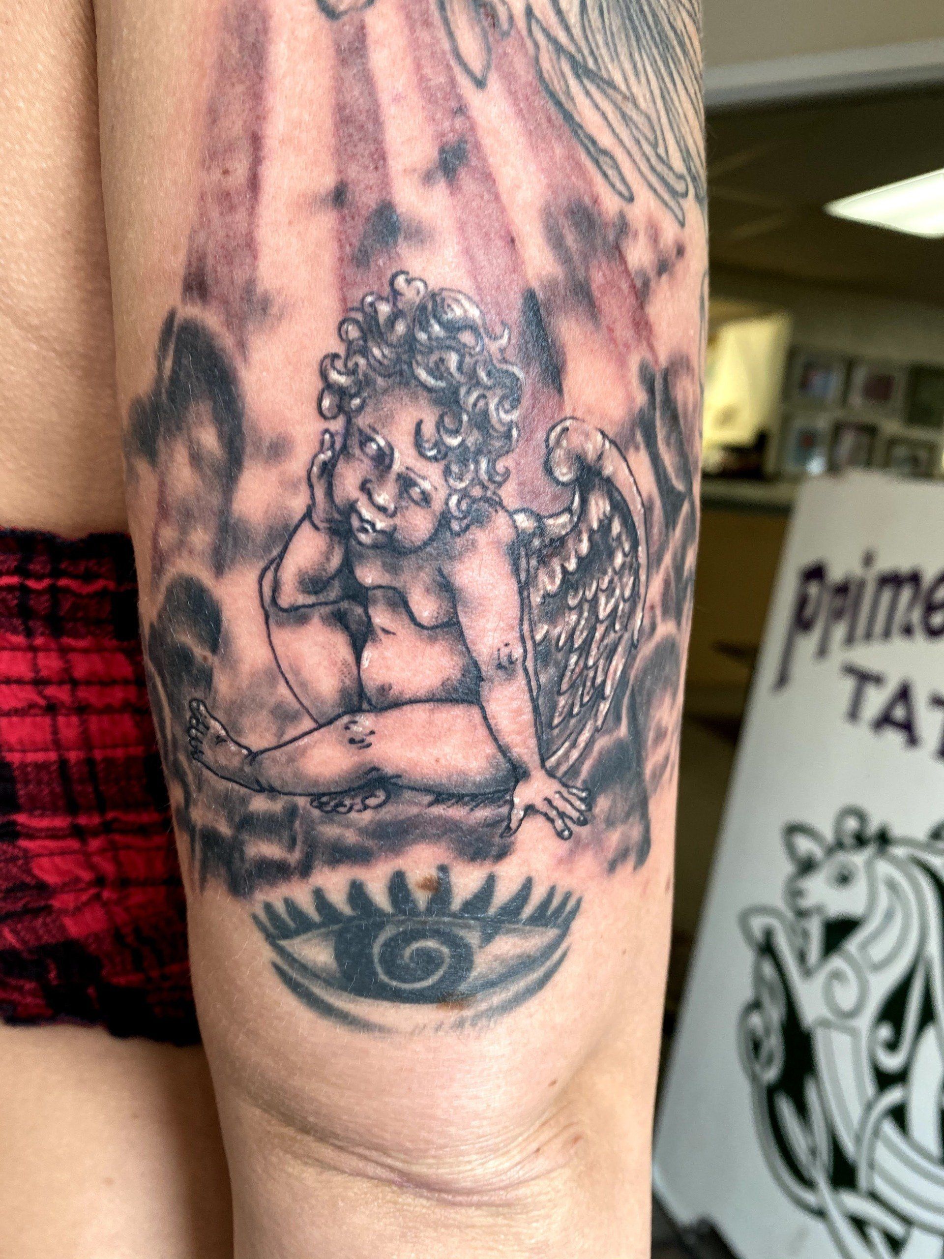 A woman has a tattoo of an angel on her arm