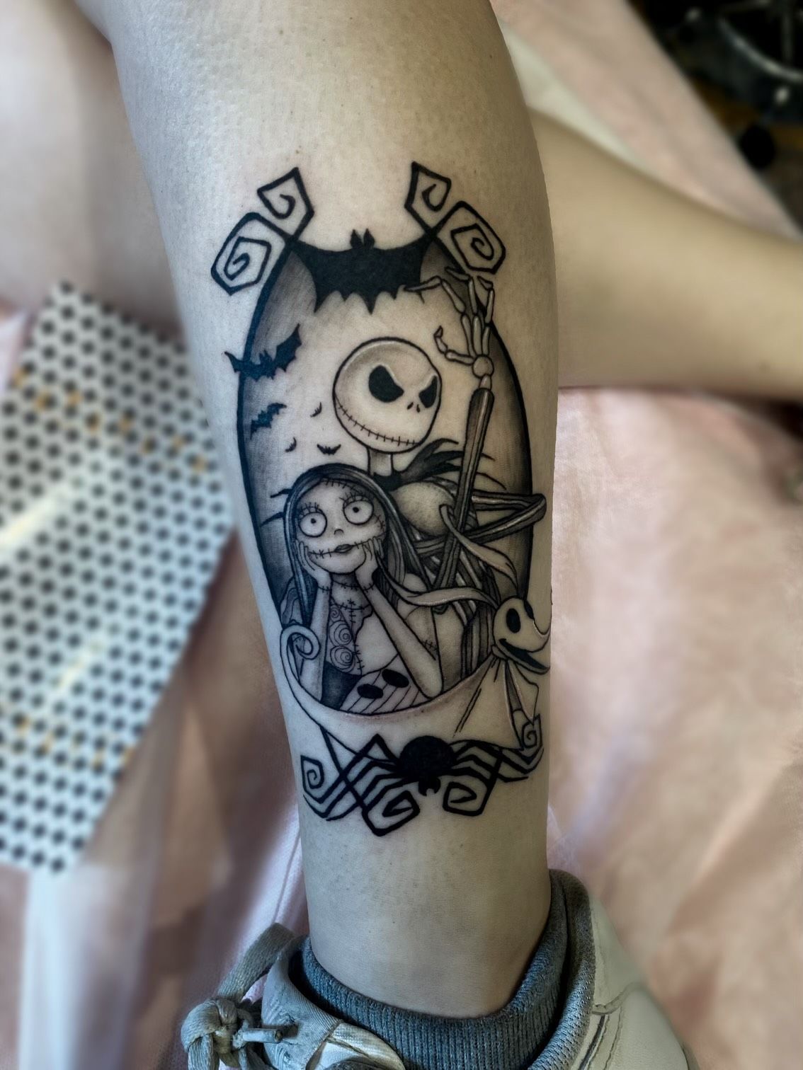 A person has a nightmare before christmas tattoo on their leg