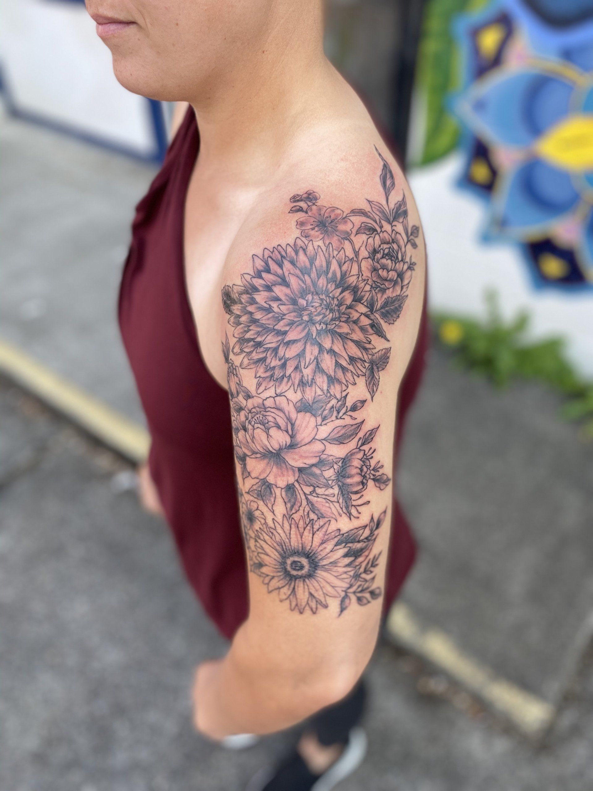 A woman has a tattoo of flowers on her arm