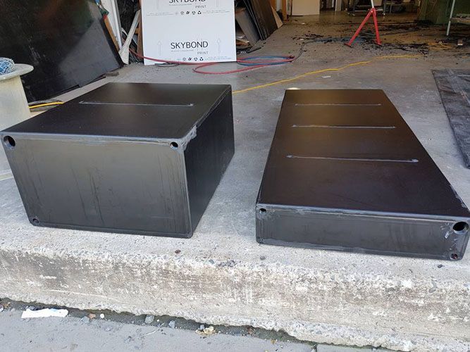 Two Black Boxes Are Sitting Next to Each Other on the Sidewalk — V.I.P. Plastic Fabrication in Portsmith, QLD