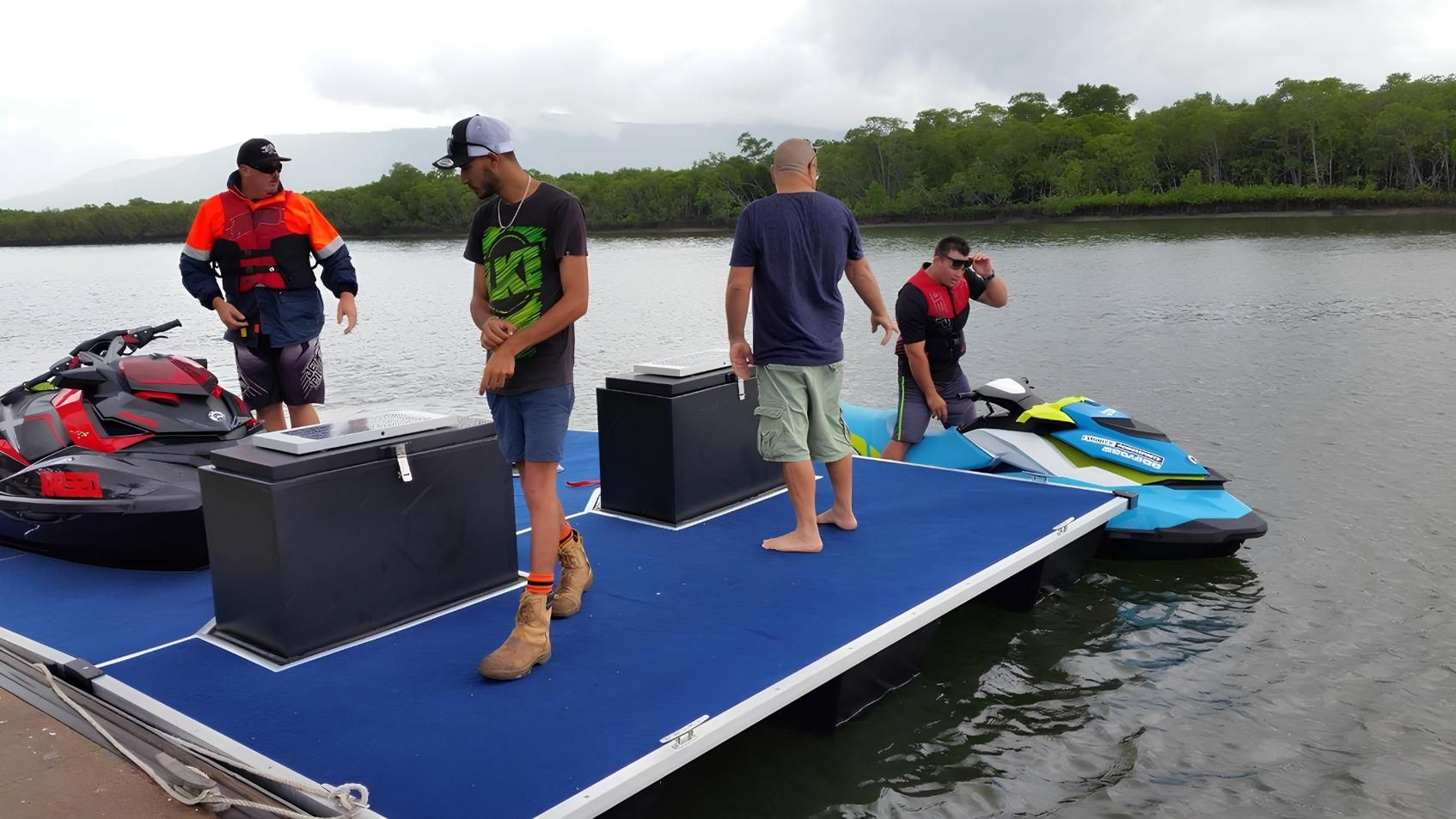 A Group of Men Are Standing on a Dock Next to Jet Skis — V.I.P. Plastic Fabrication in Portsmith, QLD