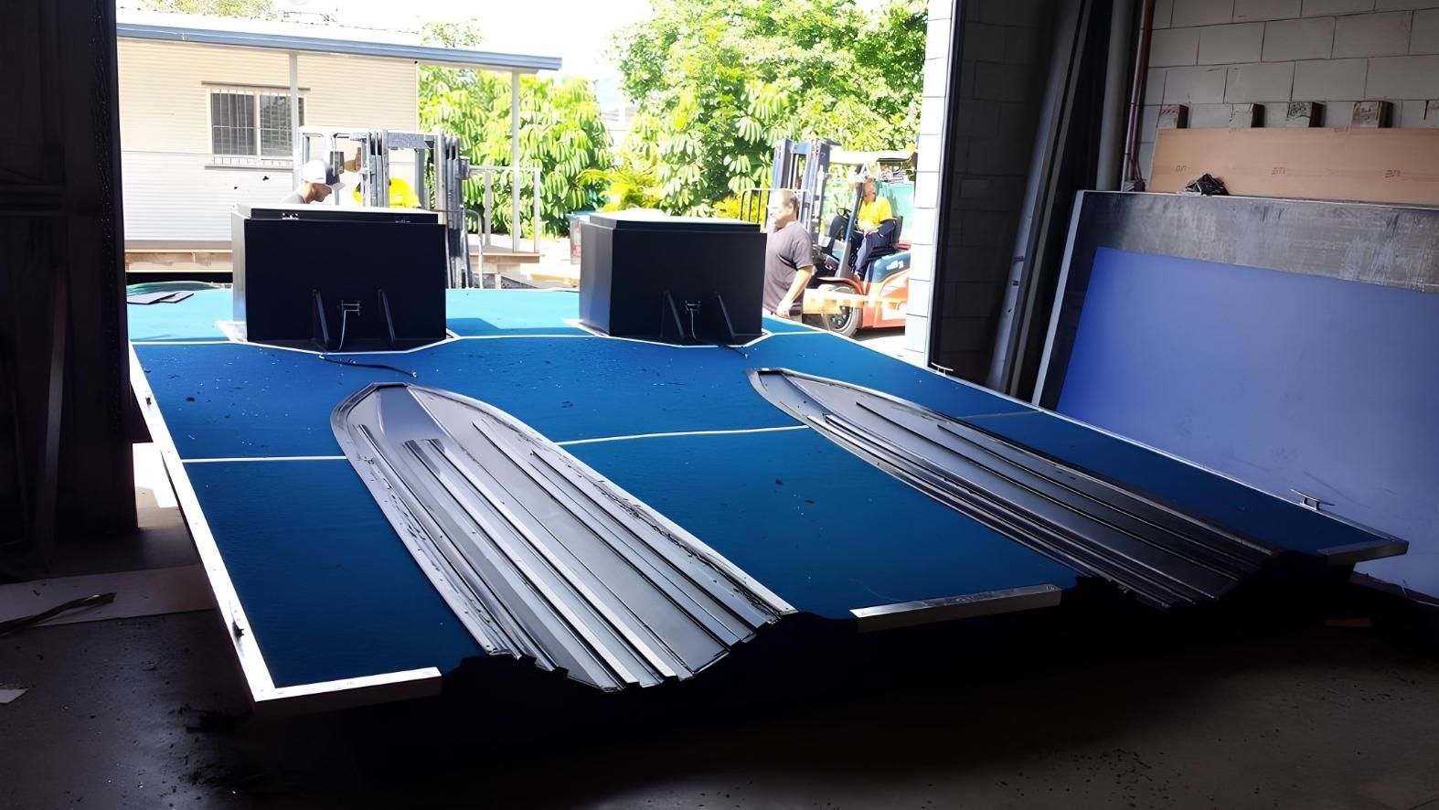 A Blue Table With a Forklift in the Background — V.I.P. Plastic Fabrication in Townsville, QLD
