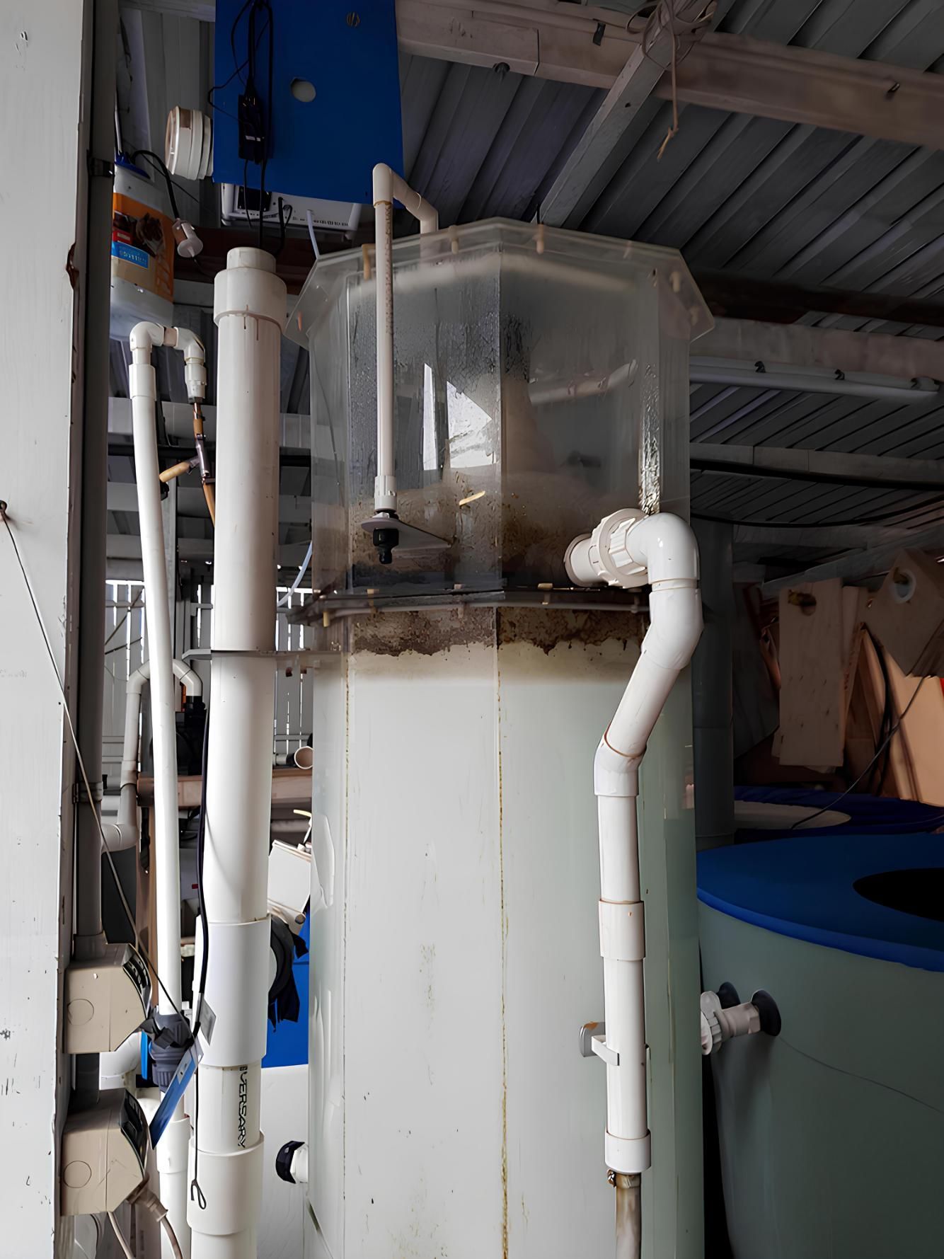 A Large Tank Filled With Water is Sitting in a Room With Pipes — V.I.P. Plastic Fabrication in Townsville, QLD