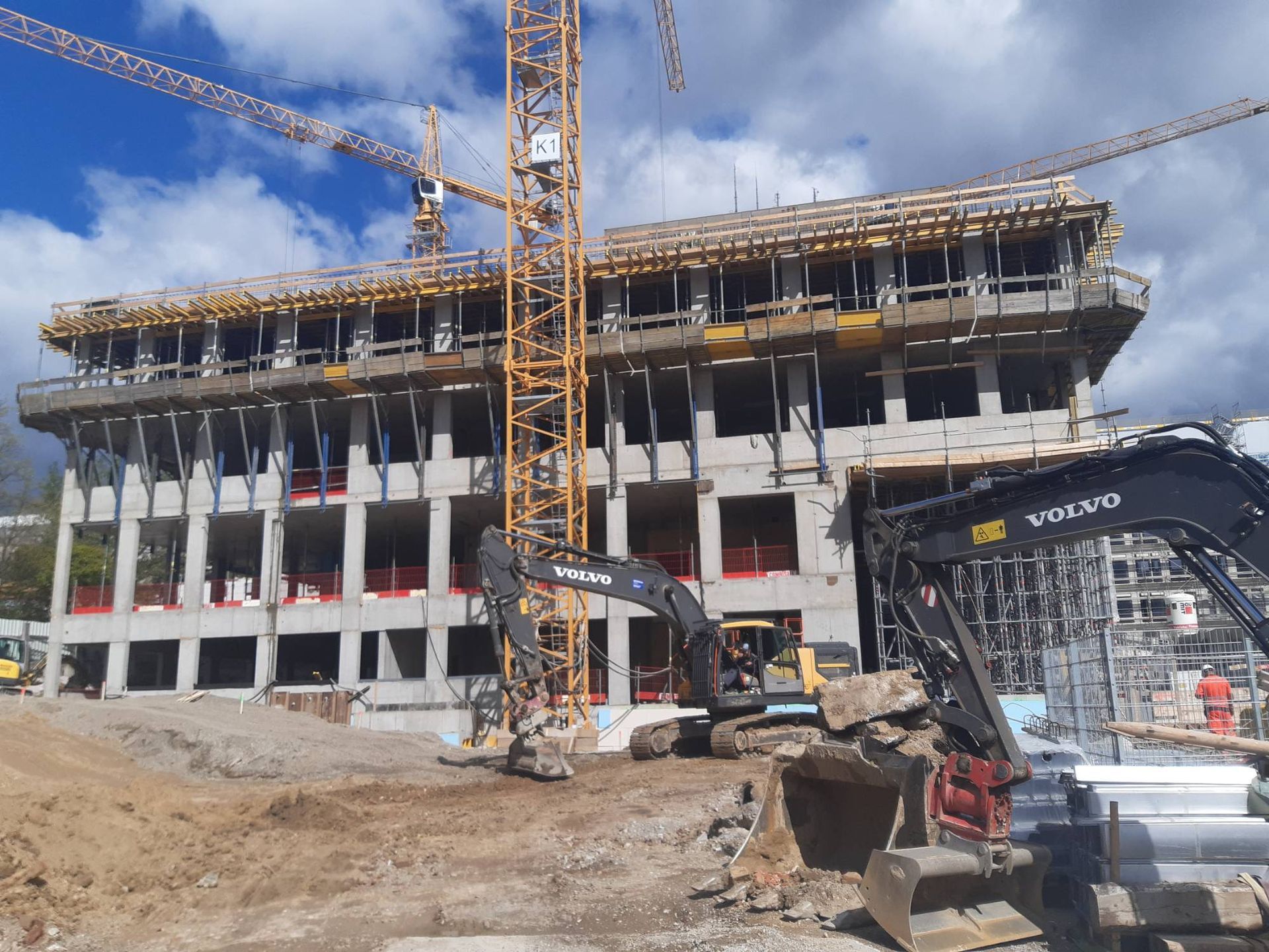 Es wird ein großes Gebäude errichtet, mit vielen Maschinen davor.